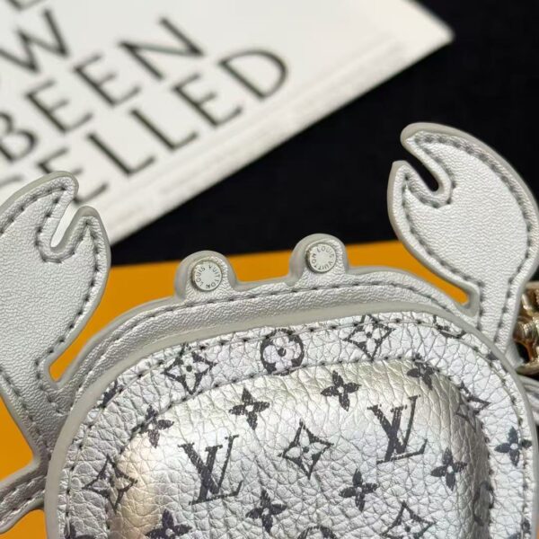 Macro view of luxury crab-shaped keychain pouch texture, showing metallic shine and fine leather grain.